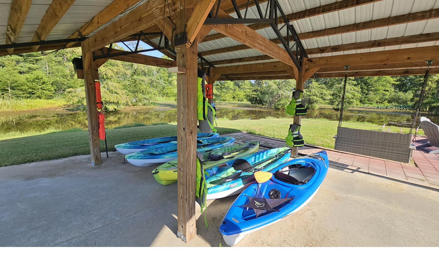Rental kayaks and life jackets ready under the pavilion at Cypress Landing