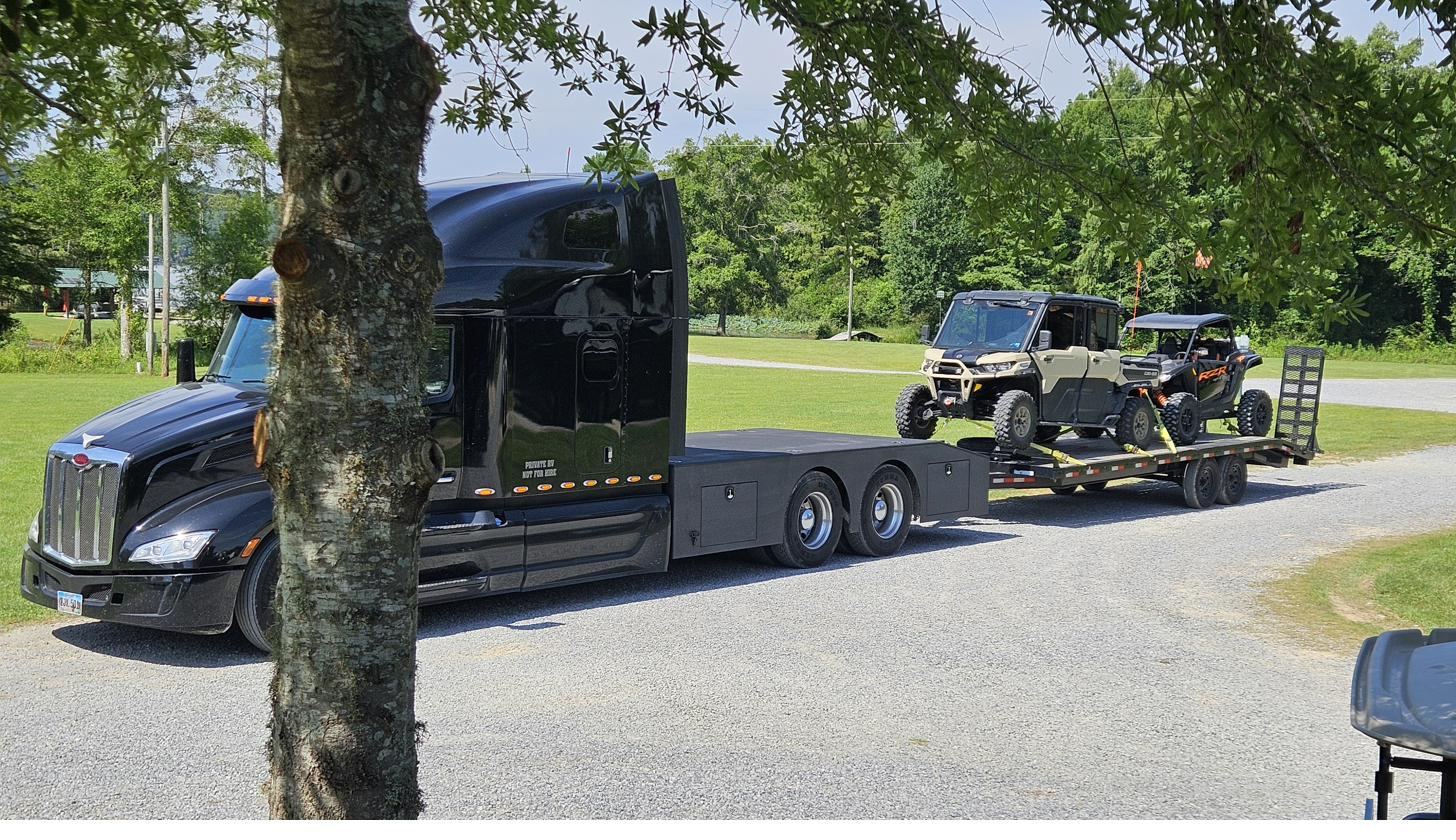 A converted semi-truck toter home with trailer parked at Cypress Landing