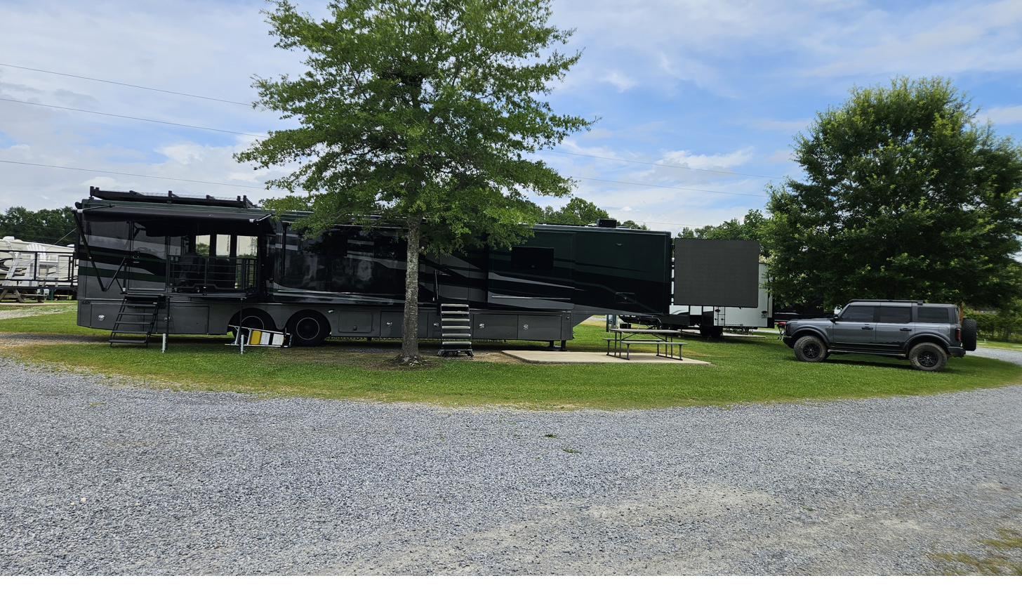 A motorcoach on a spacious full-hookup RV site at Cypress Landing