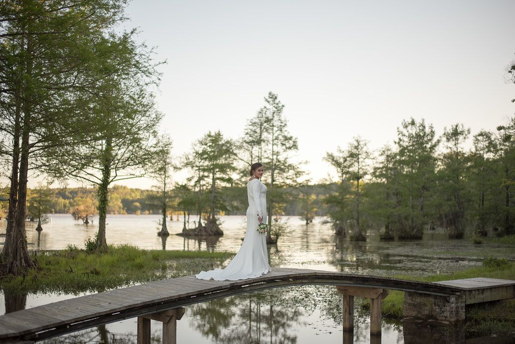 A bride on the footbridge among the cypress trees of Gantt Lake at Cypress Landing